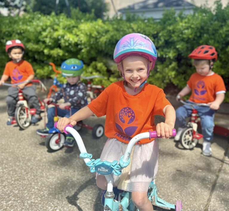 Photo of preschool kids during recess on bicycles and tricycles