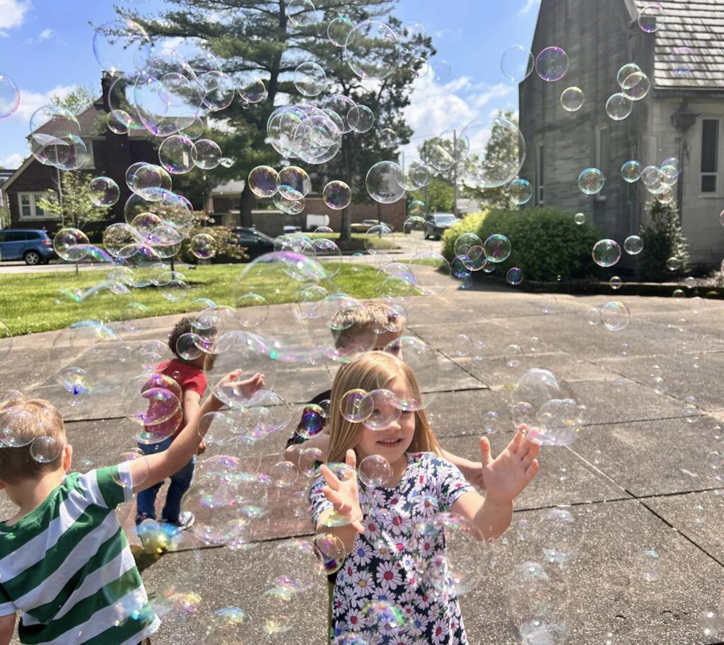 Photo of preschool kids outside during recess playing with bubbles